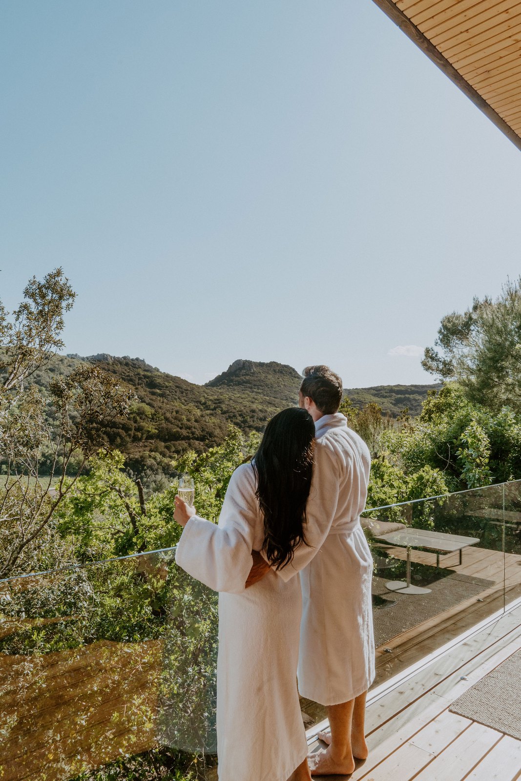 Deux voyageurs en peignoir face aux collines depuis la terrasse, Souki Lodges & Spa, Cabrières (Hérault)