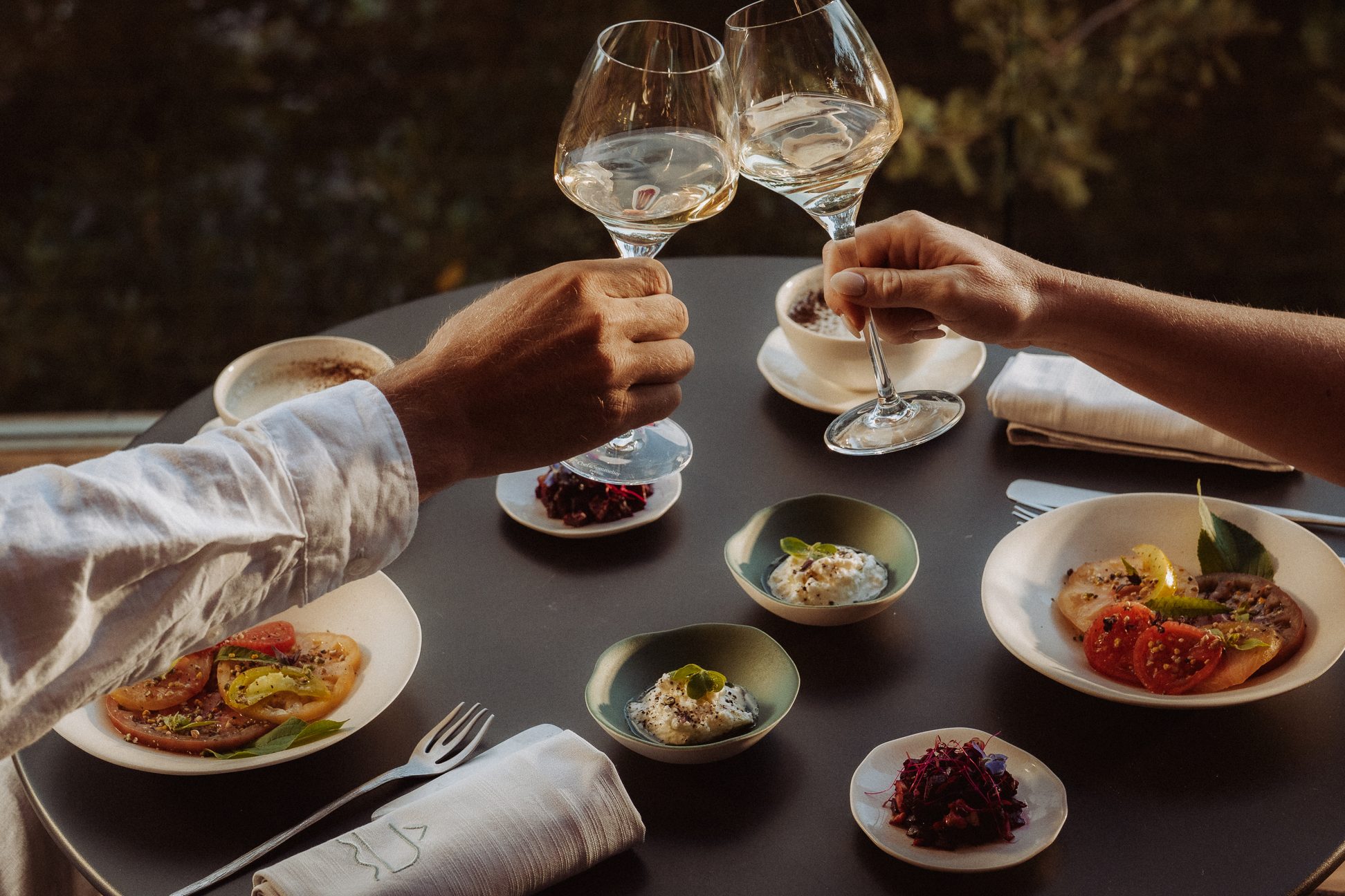 Trinquer au vin blanc lors d’un dîner gastronomique à Souki Lodges & Spa