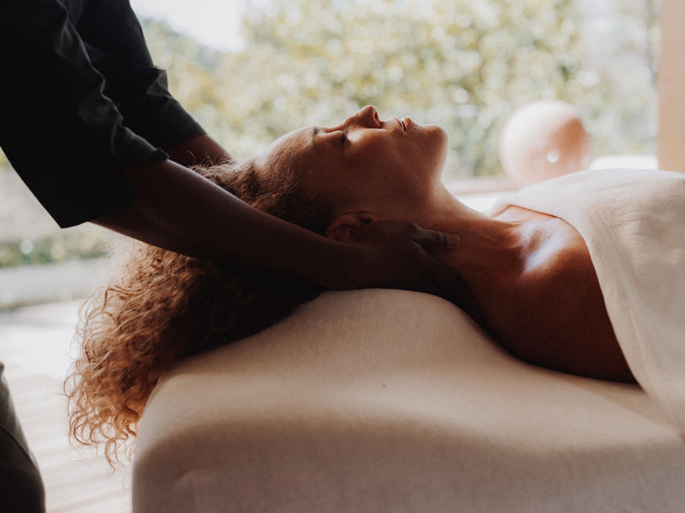 Massage de la nuque : les mains de la praticienne sous la tête, le visage détendu